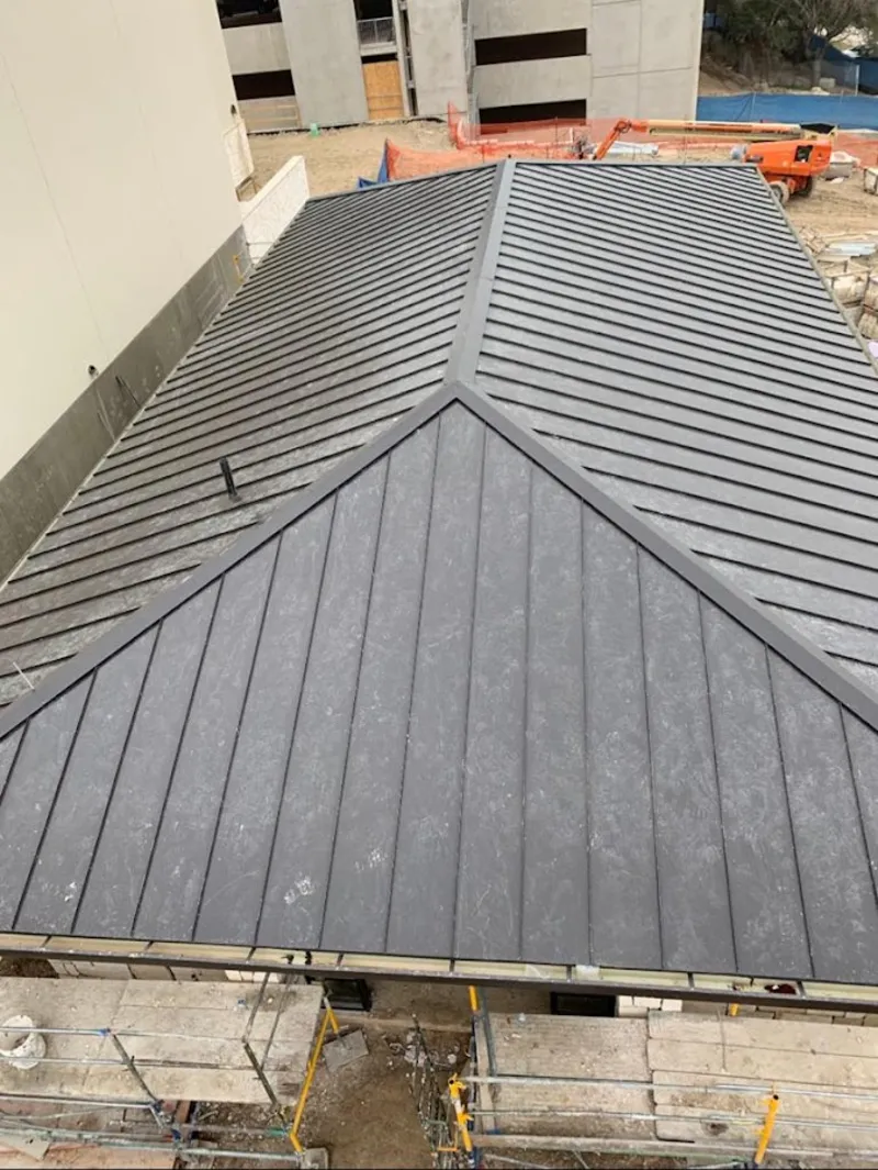 Commercial metal roof construction with crane equipment in Pompton Lakes